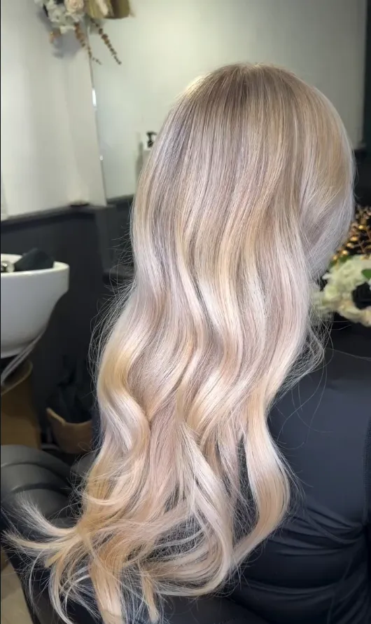 Long champagne-blonde waves, seen from behind in the studio