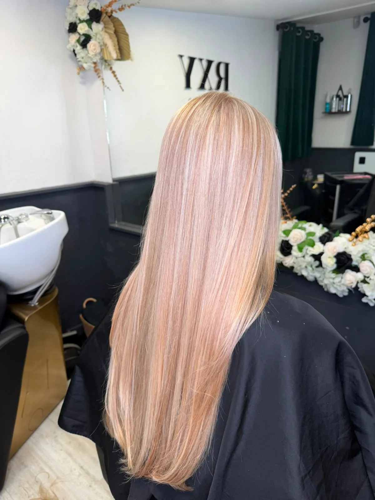 Long straight dimensional blonde highlights seen from behind in the studio