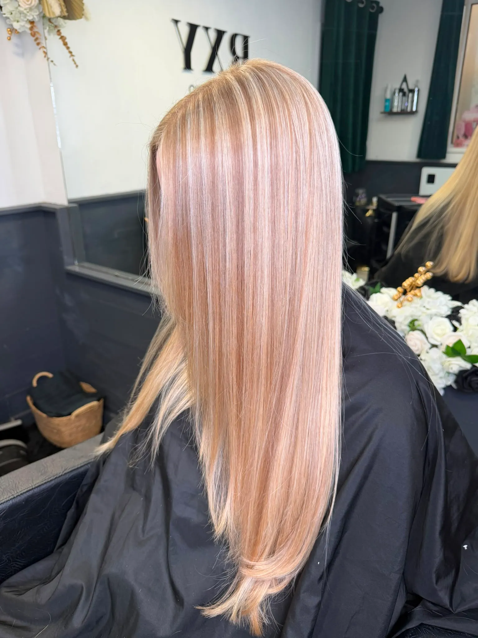 Long sleek dimensional blonde hair, straight finish, seen from behind